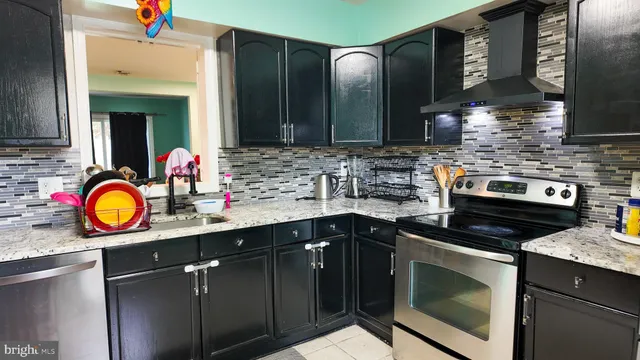 a kitchen with stainless steel appliances granite countertop a sink stove and cabinets