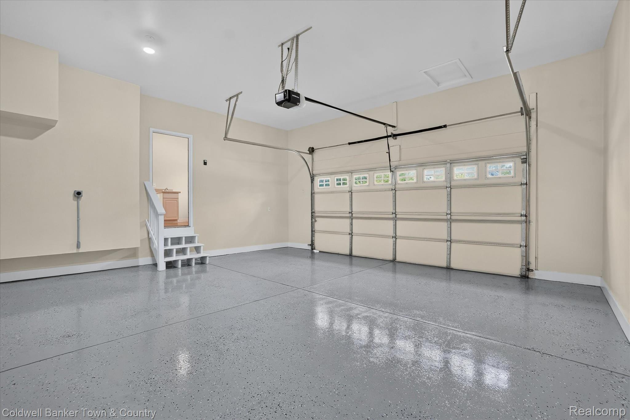 1725 Town Commons Drive Howell, MI 48855 - Photo 23 of 53 Spacious garage featuring a durable epoxy floor, automatic garage door opener, interior access door, and painted walls