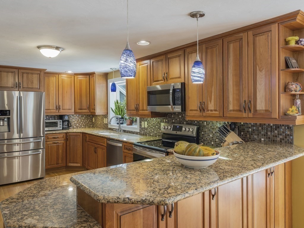 2 Deer Run Road Easton, MA 02356 - Photo 14 of 42 a kitchen with stainless steel appliances granite countertop a stove a sink dishwasher and a refrigerator with wooden cabinets