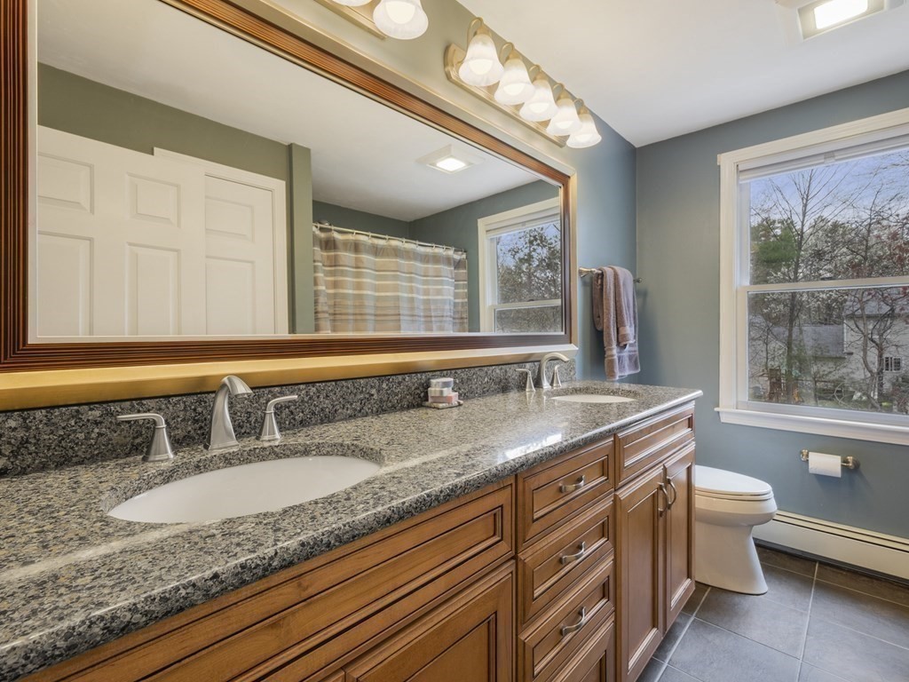 2 Deer Run Road Easton, MA 02356 - Photo 33 of 42 a bathroom with a granite countertop sink a toilet a mirror and a window