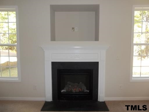 3231 Sunbright Lane Raleigh, NC 27610 - Photo 15 of 15 a living room with a fireplace and a window