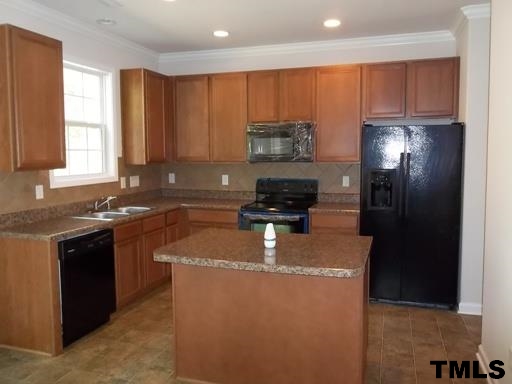 3231 Sunbright Lane Raleigh, NC 27610 - Photo 2 of 15 a kitchen with kitchen island granite countertop a stove top oven a sink and a refrigerator