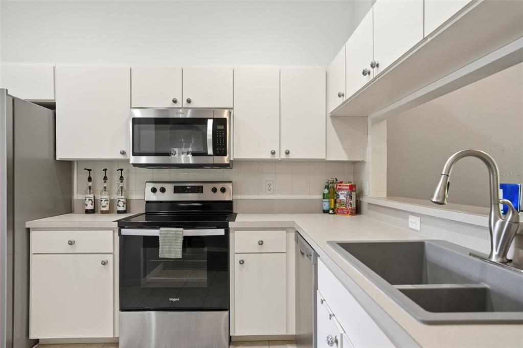12505 Cavalier Court Hudson, FL 34669 - Photo 14 of 36 a kitchen with a sink stove and microwave