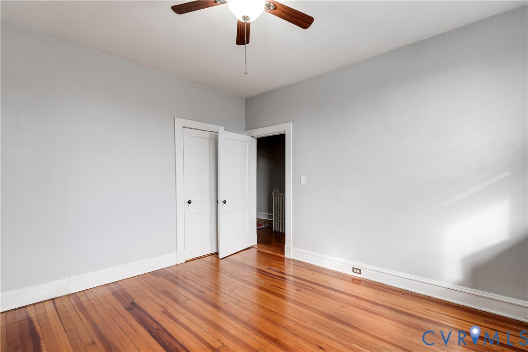 804 Cleveland Street Richmond, VA 23221 - Photo 22 of 25 an empty room with wooden floor chandelier fan and windows