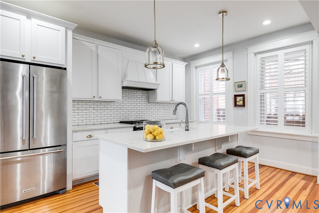 804 Cleveland Street Richmond, VA 23221 - Photo 8 of 25 a kitchen with stainless steel appliances a sink a stove a refrigerator a center island and a window