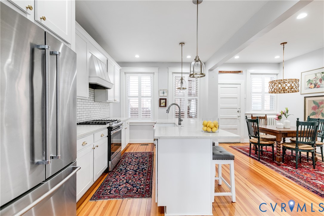 804 Cleveland Street Richmond, VA 23221 - Photo 9 of 25 a kitchen with stainless steel appliances a refrigerator a stove a sink dishwasher and white cabinets with wooden floor