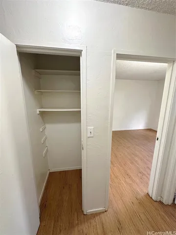 a view of walk in closet with wooden floor