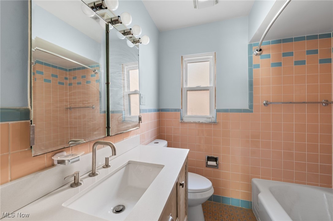 18122 Nottingham Road Cleveland, OH 44119 - Photo 16 of 29 Full bathroom with vanity, tub / shower combination, tile walls, and a tile patterned flooring