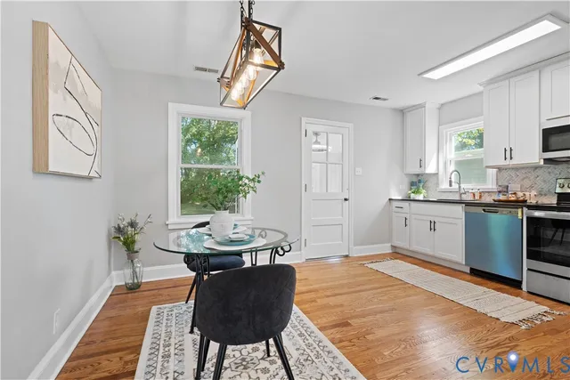 a kitchen with stainless steel appliances kitchen island granite countertop a sink a counter space and a window