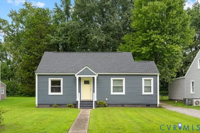 a backyard of a house with potted plants and large tree
