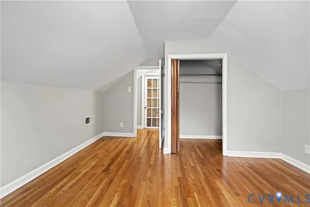 an empty room with wooden floor and closet