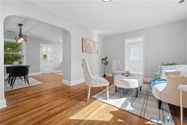 a living room with furniture a dining table and a potted plant