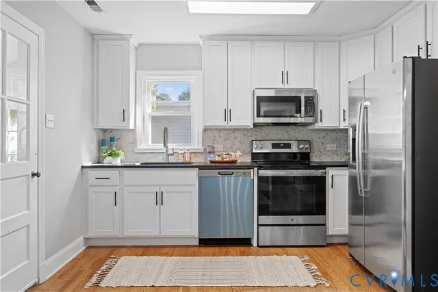 a kitchen with granite countertop a refrigerator and a stove top oven