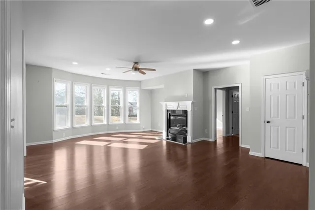 a view of empty room with wooden floor and fireplace