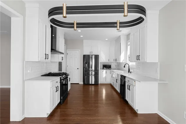a kitchen with stainless steel appliances a stove a sink and cabinets
