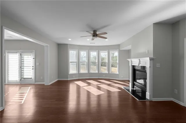 a view of wooden floor and a chandelier fan in a room