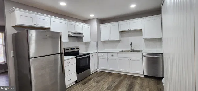 a kitchen with stainless steel appliances a refrigerator sink and microwave