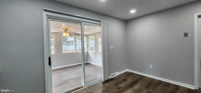 an empty room with sliding glass door and windows