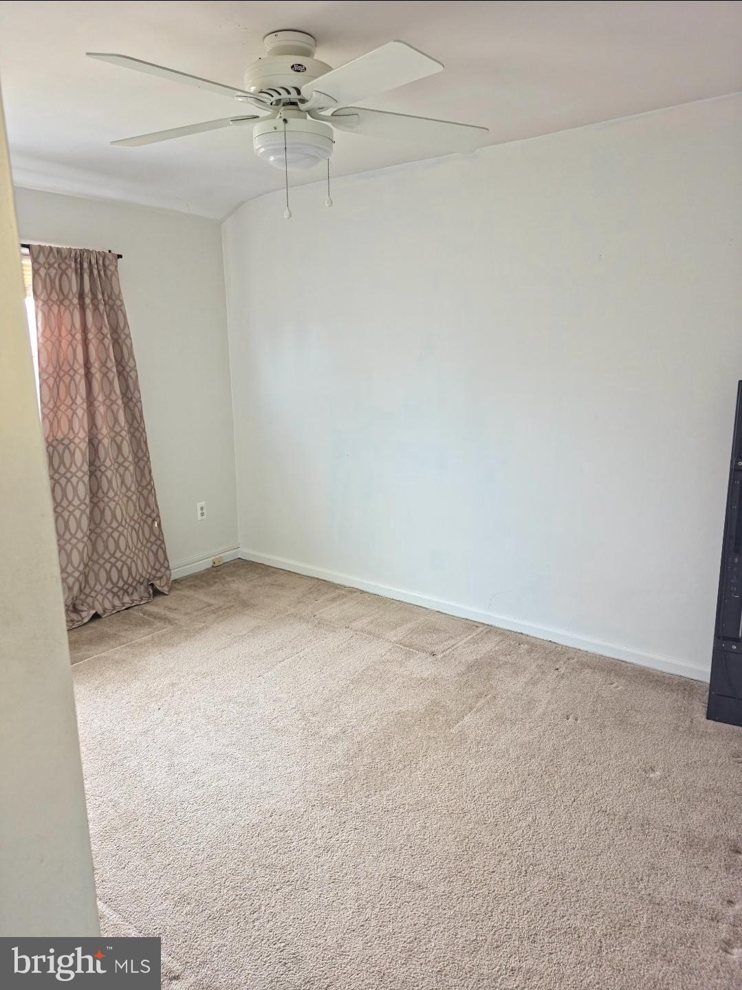 253 Southeastern Court Baltimore, MD 21221 - Photo 8 of 9 an empty room with a ceiling fan and a window