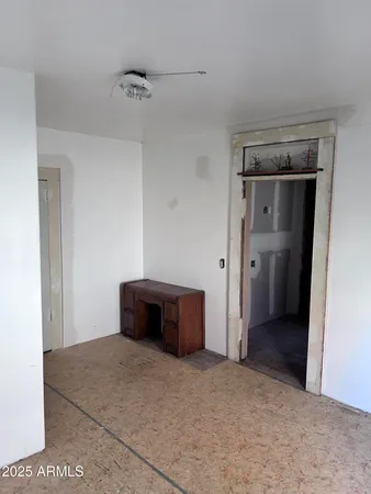 a view of a big room with wooden floor and a kitchen