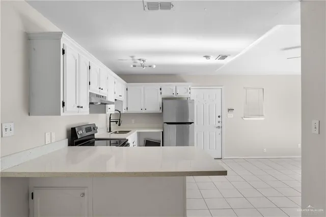 a kitchen with stainless steel appliances a refrigerator sink and cabinets