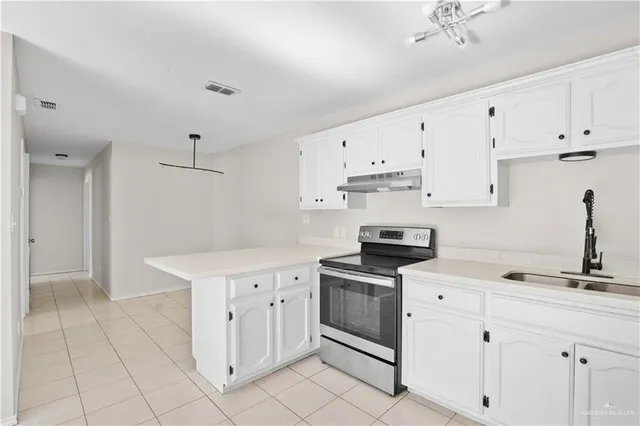 a kitchen with cabinets stainless steel appliances and sink
