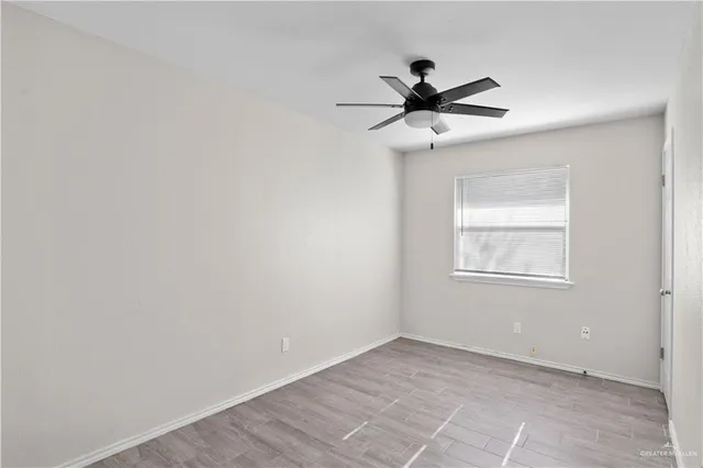 an empty room with a window and a fan