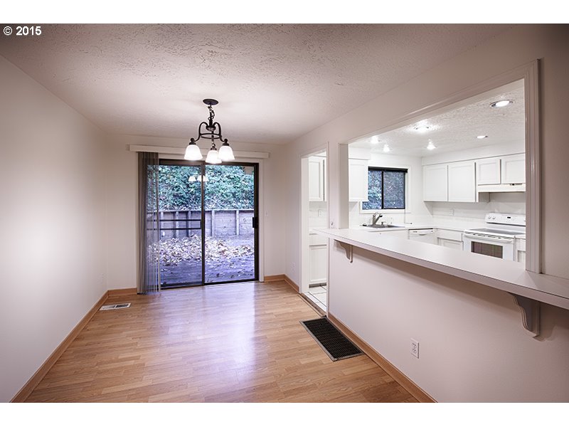31 Southwest Taylors Ferry Road Portland, OR 97219 - Photo 7 of 23 a open kitchen with granite countertop a stove top oven a sink dishwasher and white cabinets with wooden floor