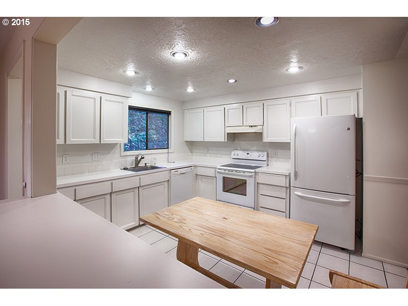 31 Southwest Taylors Ferry Road Portland, OR 97219 - Photo 8 of 23 a kitchen with white cabinets and stainless steel appliances
