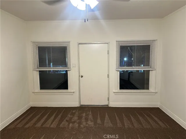 an empty room with wooden floor and cabinet