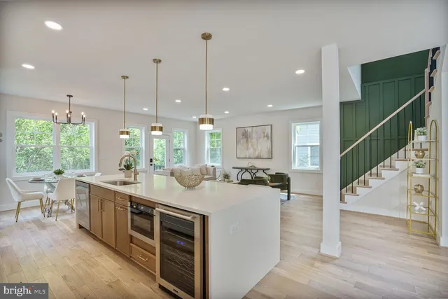 a kitchen with kitchen island a sink a stove a dining table and chairs