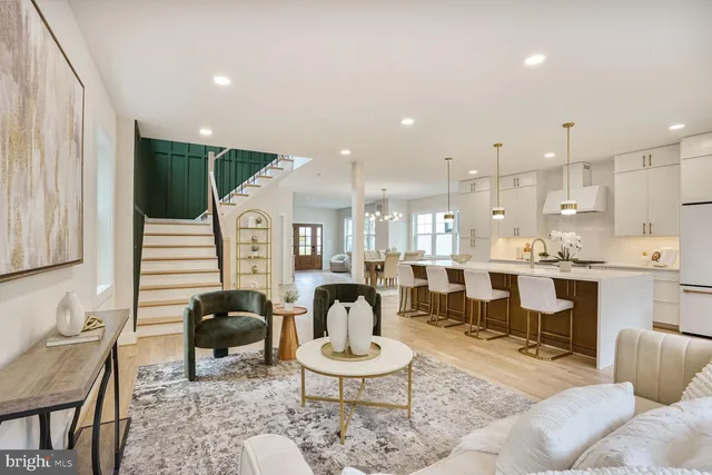 a living room with furniture a rug and kitchen view
