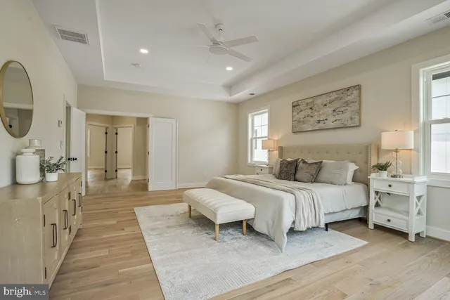 a spacious bedroom with a large bed and a chandelier