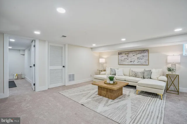 a living room with furniture and a view of bathroom