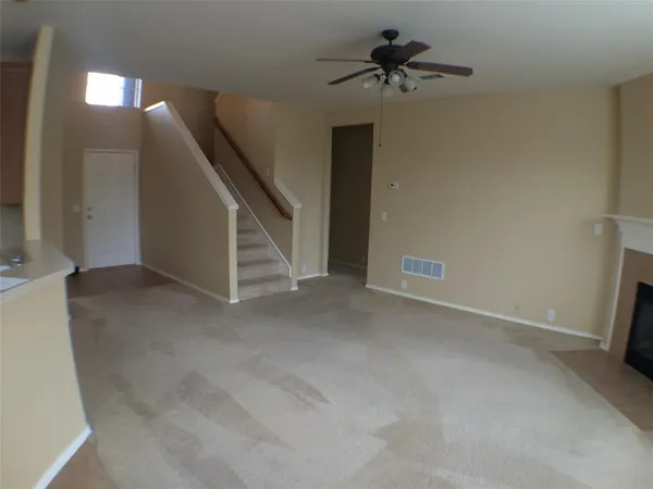 a view of an empty room with a ceiling fan