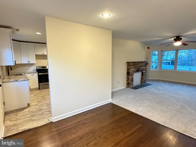 an empty room with a fireplace and wooden floor