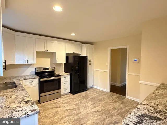 a kitchen with stainless steel appliances granite countertop a refrigerator stove and sink