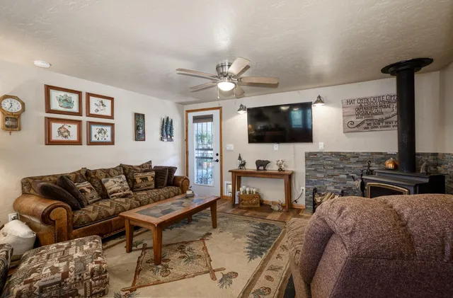 a living room with furniture kitchen view and a chandelier