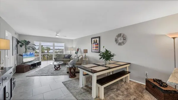 a view of a dining room with furniture a kitchen and chandelier