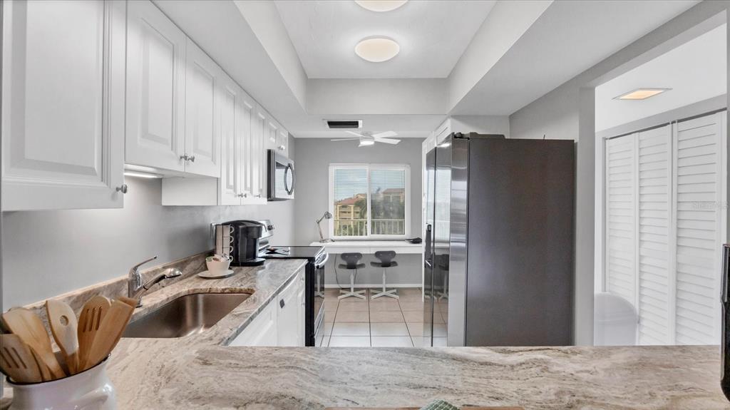 8625 Midnight Pass Road, Unit 506B Sarasota, FL 34242 - Photo 16 of 37 a kitchen with granite countertop a refrigerator stove and sink