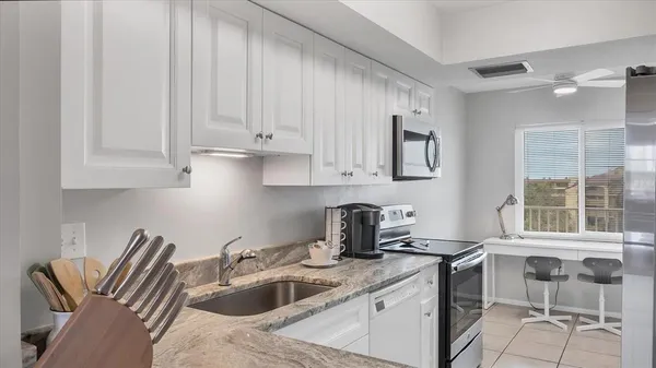 a kitchen with appliances a sink and cabinets