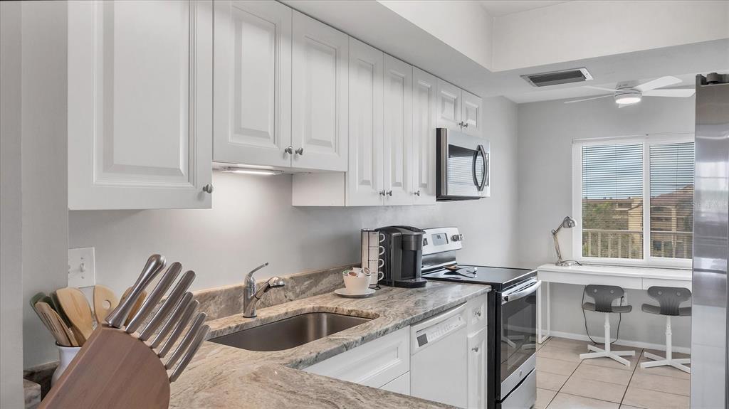 8625 Midnight Pass Road, Unit 506B Sarasota, FL 34242 - Photo 17 of 37 a kitchen with a sink cabinets and a window