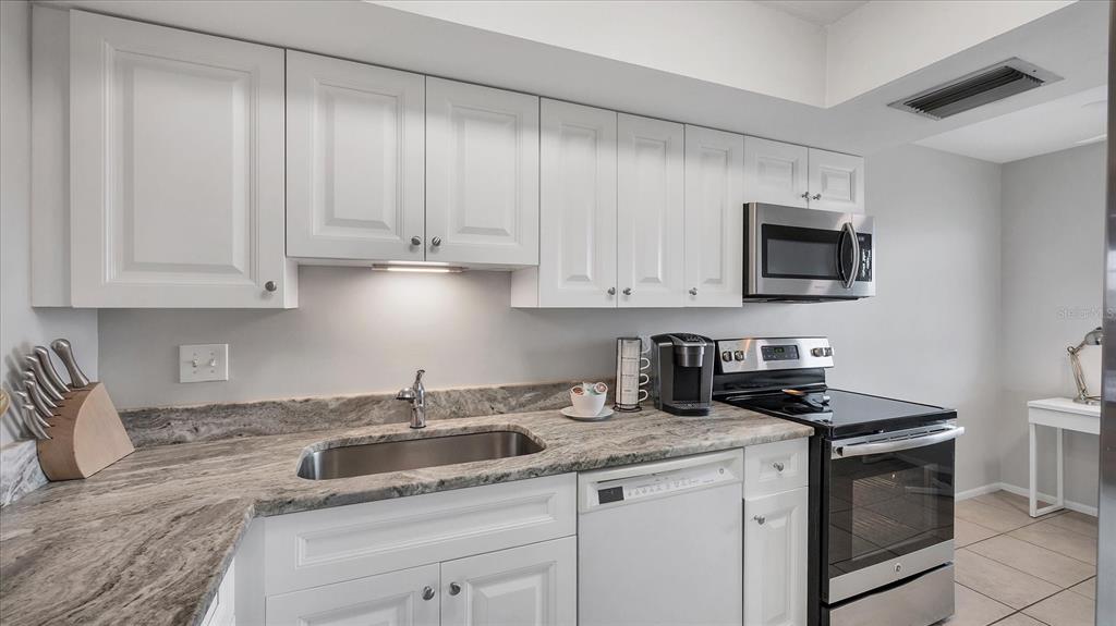 8625 Midnight Pass Road, Unit 506B Sarasota, FL 34242 - Photo 18 of 37 a kitchen with appliances a sink and cabinets