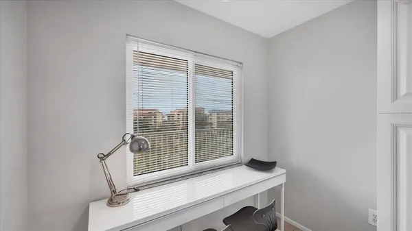 a view of a workspace with furniture and a window