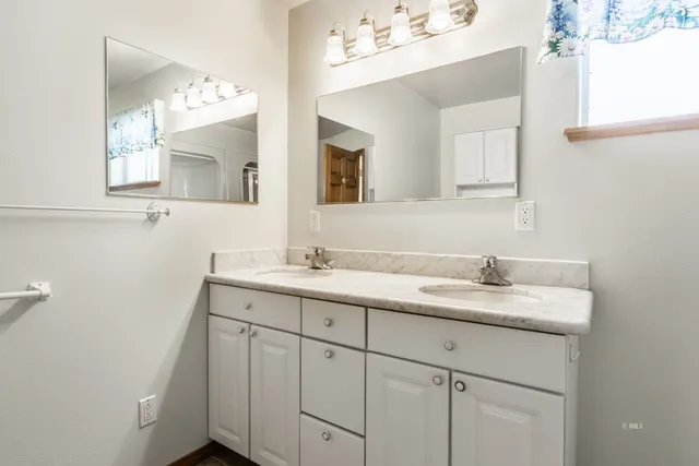 a bathroom with a granite countertop sink double and mirror
