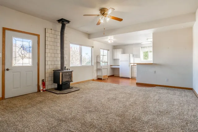 a view of a kitchen with furniture a ceiling fan and window