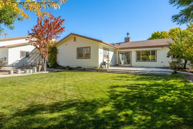 a front view of house with yard and trees around