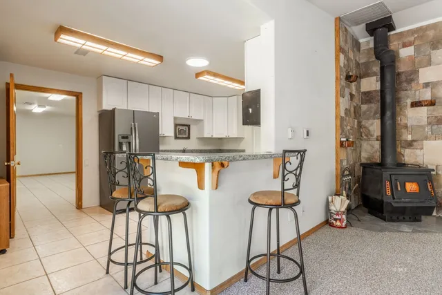 a kitchen with stainless steel appliances kitchen island granite countertop a refrigerator and cabinets