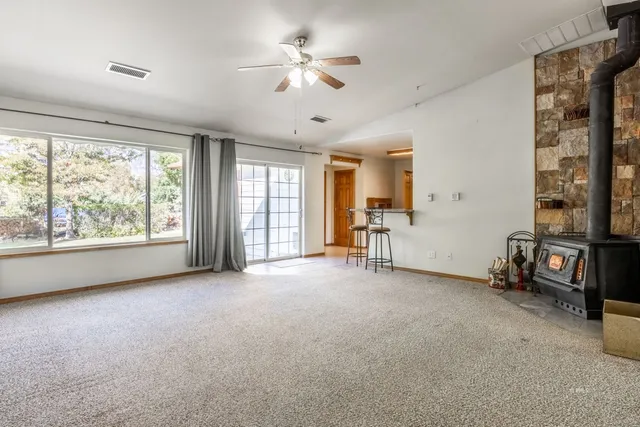 an empty room with windows and ceiling fan