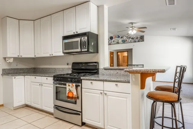 a kitchen with stainless steel appliances granite countertop a stove a sink and a microwave